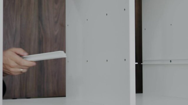 Installation of a drawer on guides in a cabinet. Furniture assembler by handyman