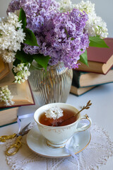 Cup of tea, bouquet of lilacs, spring still life.