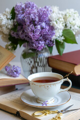 Cup of tea, bouquet of lilacs, spring still life.