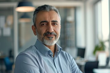 Obraz premium Professional middle-aged man with a beard and serious expression in contemporary office