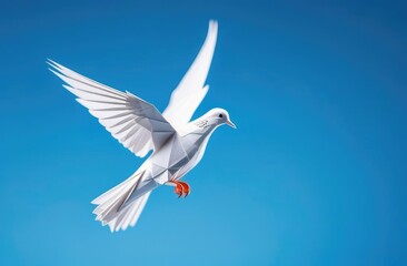 Obraz premium white pigeon made of paper on a blue background. The dove of peace. An origami figurine.