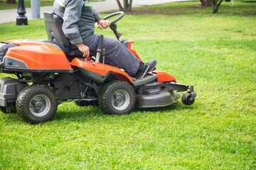 Obraz premium Lawn mower. Mowing the lawn by a utility worker.