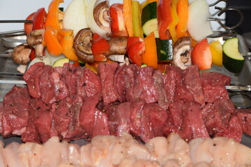 raw beef, chicken and veggie skewers prepped to cook on grill