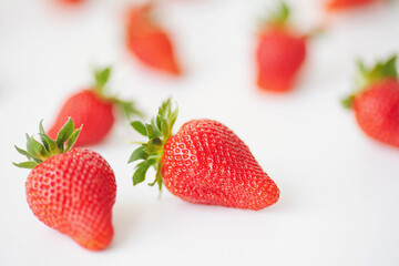 Strawberries isolated over white background. Heap of fresh strawberries on blurred background, selective focus.