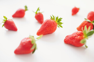 Strawberries isolated over white background. Heap of fresh strawberries on blurred background, selective focus.
