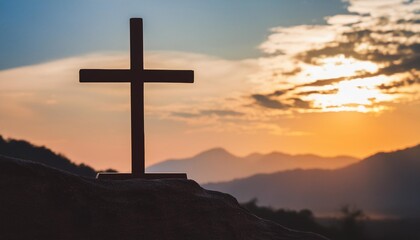 silhouette of crucifix cross on mountain at sunset sky background