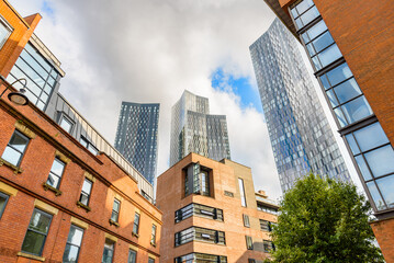 Renovated brick residential buildings overlooked by new glass apartment skyscrapers on a sunny...