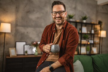 Adult caucasian man sit and hold coffee look at the camera and smile