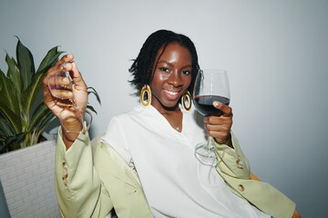Young businesswoman drinking wine at office party