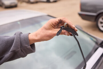 Hand changing car windshield wiper, using thumb and fingers