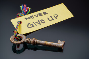 Key with NEVER VIVE UP written on paper