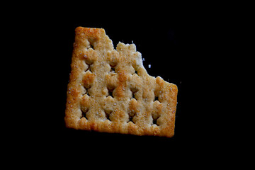 hand holding a biscuit or cracker that has been bitten