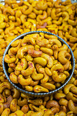 Close-Up of Saffron Cashews in a Decorative Bowl, A high-resolution image showcasing saffron-infused cashews in a decorative blue and white bowl, ideal for culinary use and healthy snacking.