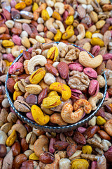 Assorted Seasoned Nuts in a Decorative Bowl Close Up, Close-up image of a decorative bowl filled with assorted seasoned nuts. The selection includes cashews, almonds, walnuts, and more.