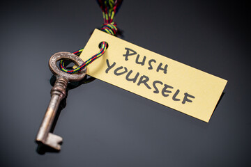 Key with PUSH YOURSELF written on paper