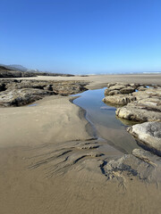 Water on a beach in Yachats, Oregon, during low tide.
