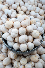 Traditional Circle Curds in Metal Bowl, Rich in Texture, Close-up of traditional circle curds dusted with flour in a dark metal bowl, surrounded by many more curds, showcasing a rich culinary texture.