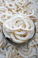 Fresh Coconut Shavings in a Metal Bowl Close-Up, Close-up image of fresh coconut shavings with skin displayed in a metal bowl, ideal for culinary uses and decoration.