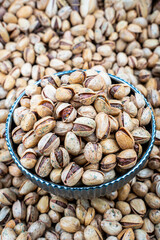 Bowl Of Thyme Pistachios Surrounded By Whole Nuts