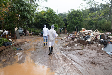 volunteers wearing raincoats taking donations to families affected by floods in southern Brazil