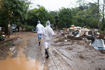 volunteers wearing raincoats taking donations to families affected by floods in southern Brazil
