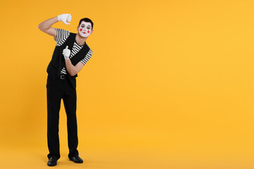 Funny mime artist posing on orange background. Space for text