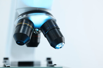 Modern microscope on light background, closeup view