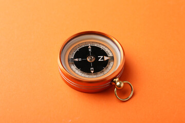 One compass on orange background. Tourist equipment