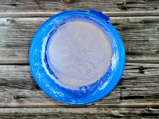 vanilla white frozen ice cream in a plastic bowl isolated on wooden background and ready to be...