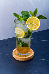 Refreshing Mint Mojito Cocktail with Lemon and Ice, A fresh and invigorating mint mojito cocktail garnished with lemon slices, mint leaves, and ice, presented in a tall glass.