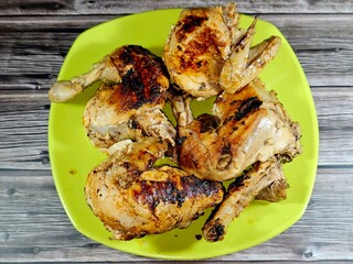 Grilled chicken on a grill on fire with some oil after being boiled in water with bones, the whole chicken with breasts, legs, thighs, chicken meat, white chicken meat, Egyptian cuisine of chickens