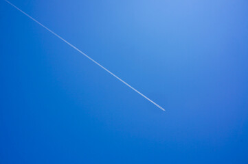 青空に美しく描かれた一直線に伸びる飛行機雲