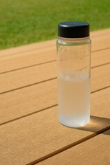  a bottle of water on the wooden table