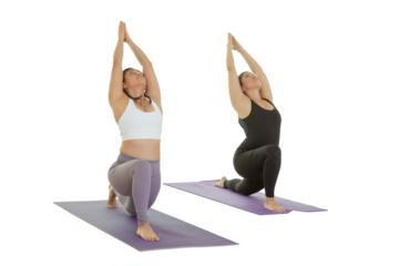 Two young Mexican women practice yoga indoors in a studio