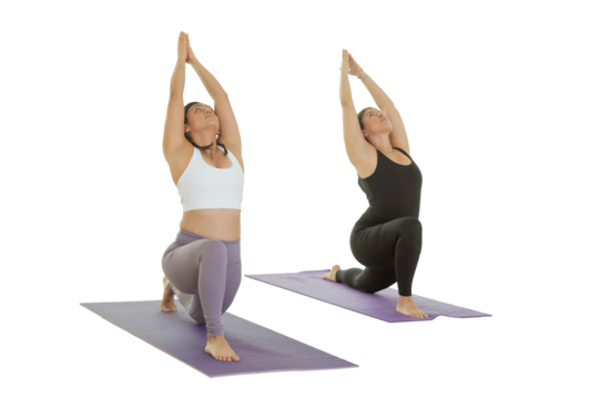 Two young Mexican women practice yoga indoors in a studio