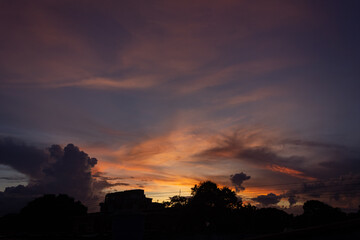 Fototapeta premium Sunset sky with clouds and silhouette of the city 