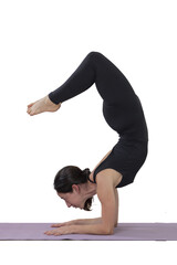 Obraz premium Young woman practicing yoga does the scorpion pose inside a photo studio