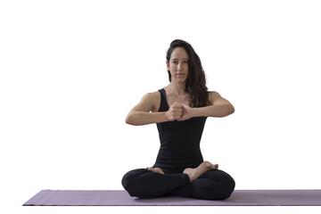 Fototapeta premium Woman in black sportswear practices yoga doing Padmasana or Lotus Pose inside a studio