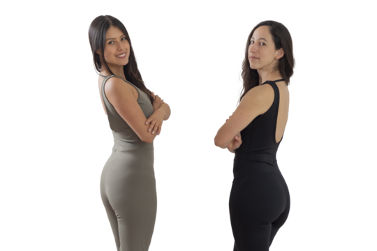 Two women in sportswear looking at the camera with their arms crossed and a manaste sign in the background - Powered by Adobe