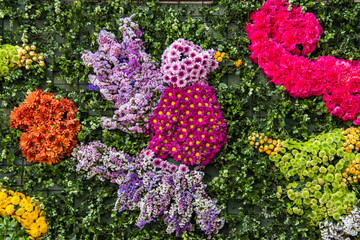 A colorful arrangement of flowers and plants, including a bird