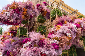 A large flower arrangement is suspended from the ceiling of a building