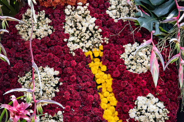 A flower arrangement with red and yellow flowers and white flowers