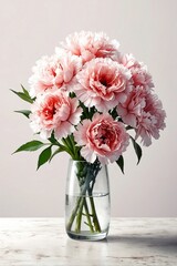 a bouquet of freshly cut carnation flowers arranged in a glass vase on a white tabletop - obrazy, fototapety, plakaty