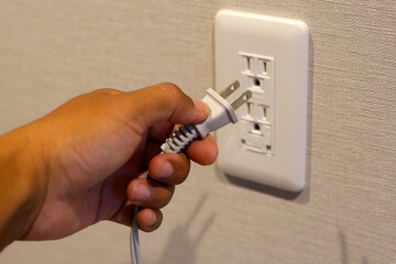 Hand insert a plug of the phone charger into socket.