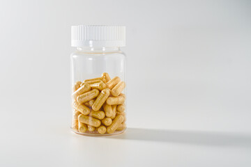 Transparent bottle with pills on white background