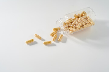 Transparent bottle with pills on white background