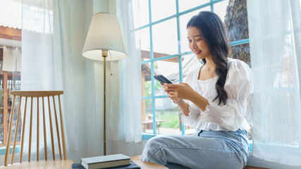 Young asian businesswoman using smartphone to chat texting message and checking good news in email...