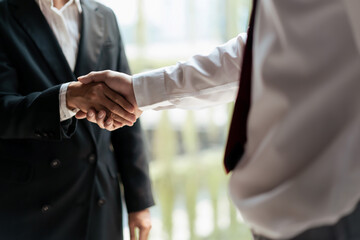 HR manager woman shaking hand with male candidate after successful job interview in office