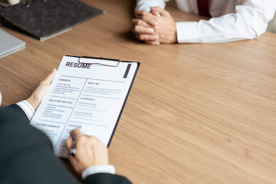 HR manager woman reading resume and asking questions with male candidate while job interviewing