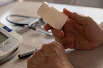 Hands of a doctor at his desk holding a medicine bottle. Health care.